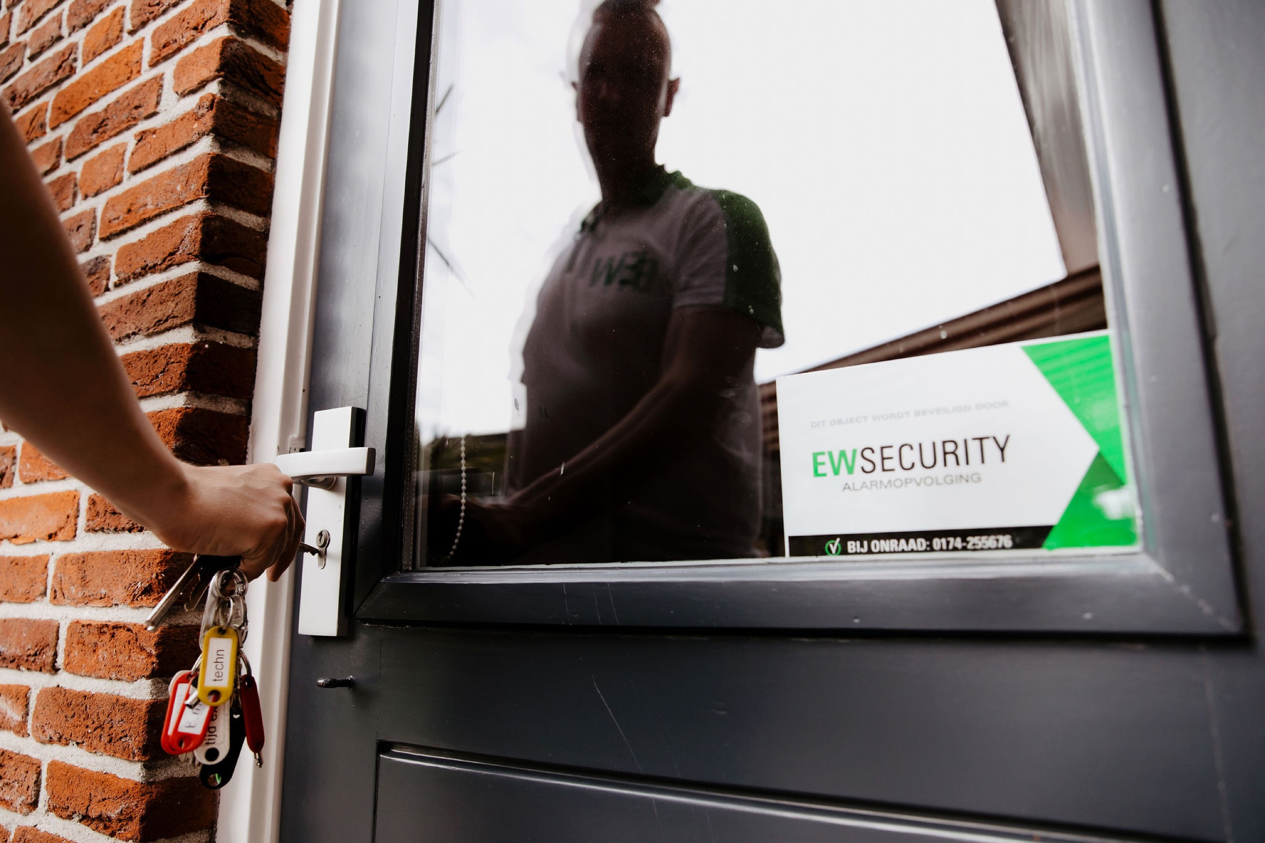 Beveiliger opent een woning met sleutel tijdens een controle van EW Security
