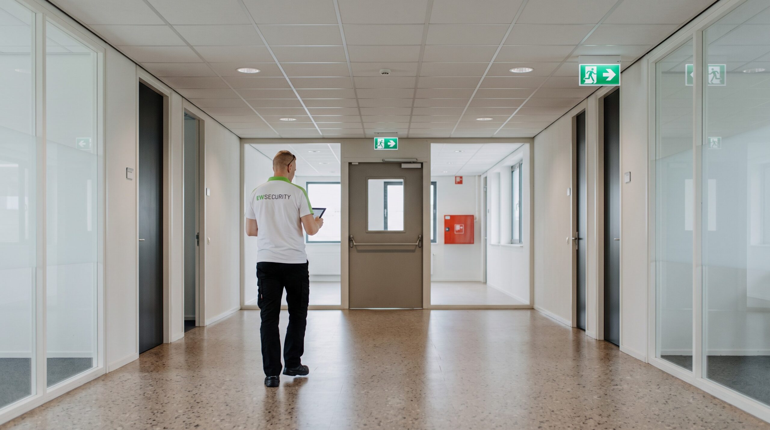 AI-beeld van EW Security: gang met vluchtrouteborden en checklist
